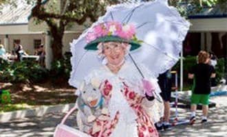 A woman dressed as a lady holding an umbrella.